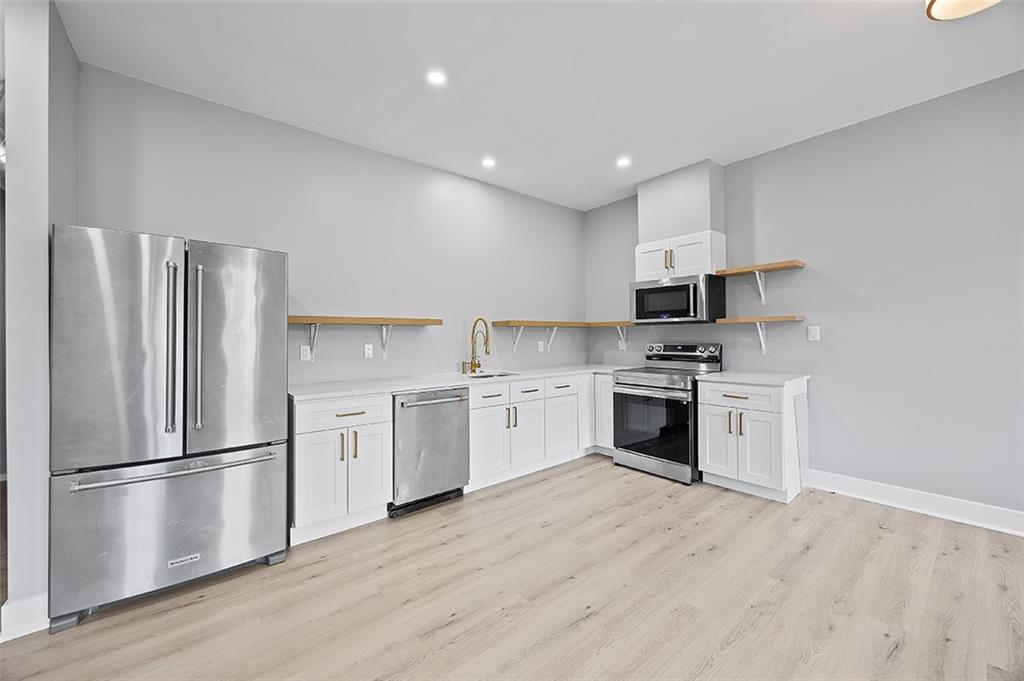 1109 East Carson Street Pittsburgh, PA 15203 - Photo 2 of 13 a kitchen with a refrigerator stove and wooden floors
