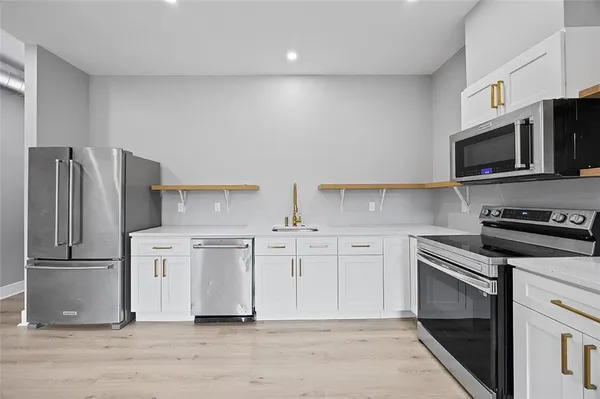 a kitchen with stainless steel appliances granite countertop a refrigerator stove and microwave
