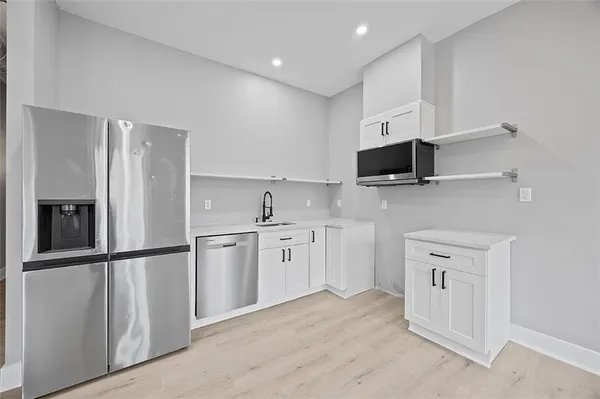 a kitchen with white cabinets and refrigerator