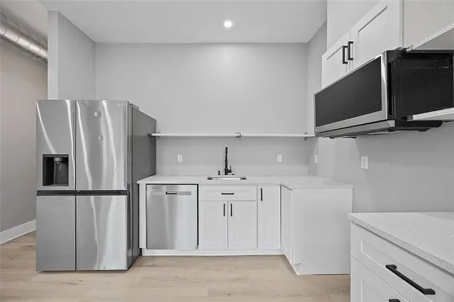 a kitchen with stainless steel appliances a refrigerator and a sink