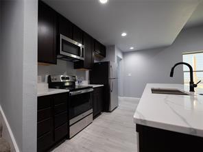 419 West Elm Street Denison, TX 75020 - Photo 3 of 9 a kitchen with stainless steel appliances granite countertop a sink a stove top oven and wooden floor