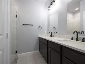419 West Elm Street Denison, TX 75020 - Photo 4 of 9 a bathroom with a double vanity sink and a mirror