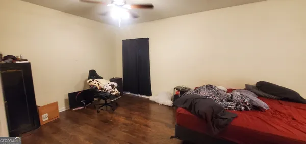 a bedroom with a bed and a flat tv screen on a dresser