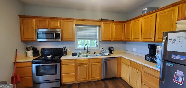 a kitchen with stainless steel appliances granite countertop a stove a sink and a refrigerator