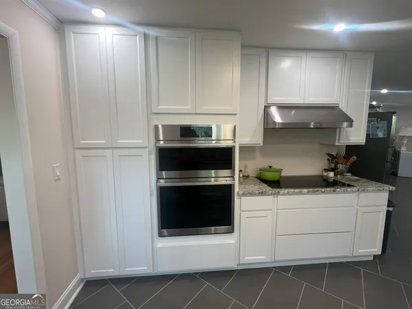 a kitchen with stainless steel appliances granite countertop a refrigerator and a stove top oven