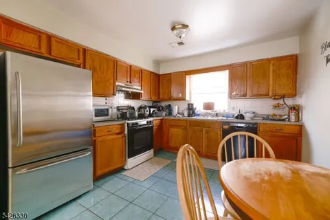 a kitchen with stainless steel appliances granite countertop a refrigerator a sink a stove and island
