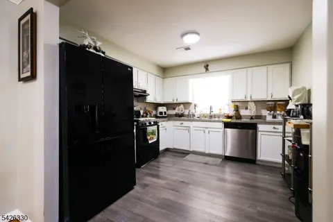 a kitchen with a refrigerator a stove top oven a sink and cabinets