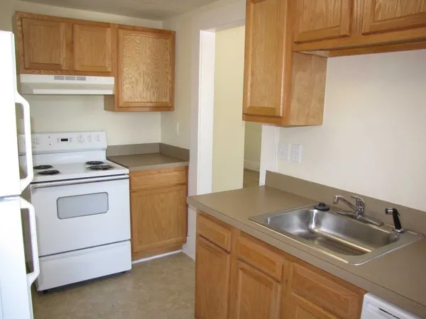 a kitchen with white cabinets and white appliances
