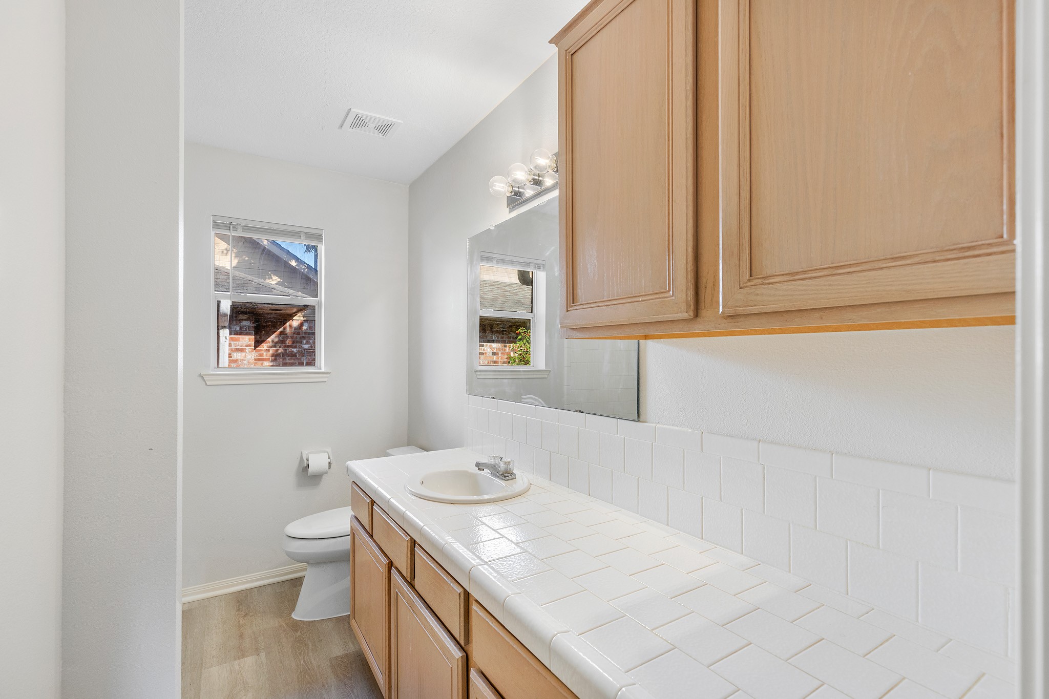 8018 Holiday Lane Houston, TX 77075 - Photo 27 of 42 a bathroom with a granite countertop sink a toilet and a window