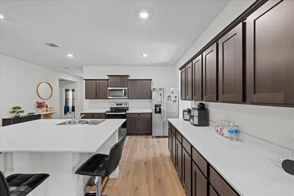 a kitchen with kitchen island granite countertop a sink appliances cabinets and a counter top space