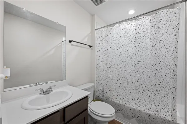a bathroom with a sink a toilet and shower curtain