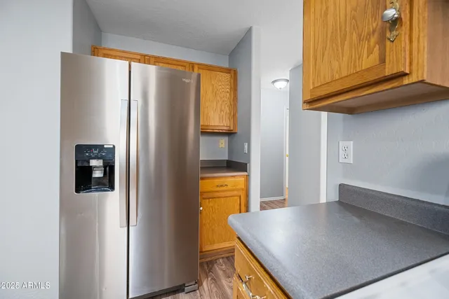 a view of a living room with a refrigerator and cabinets
