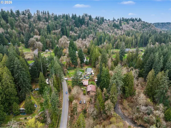 a view of a lush green forest with a house