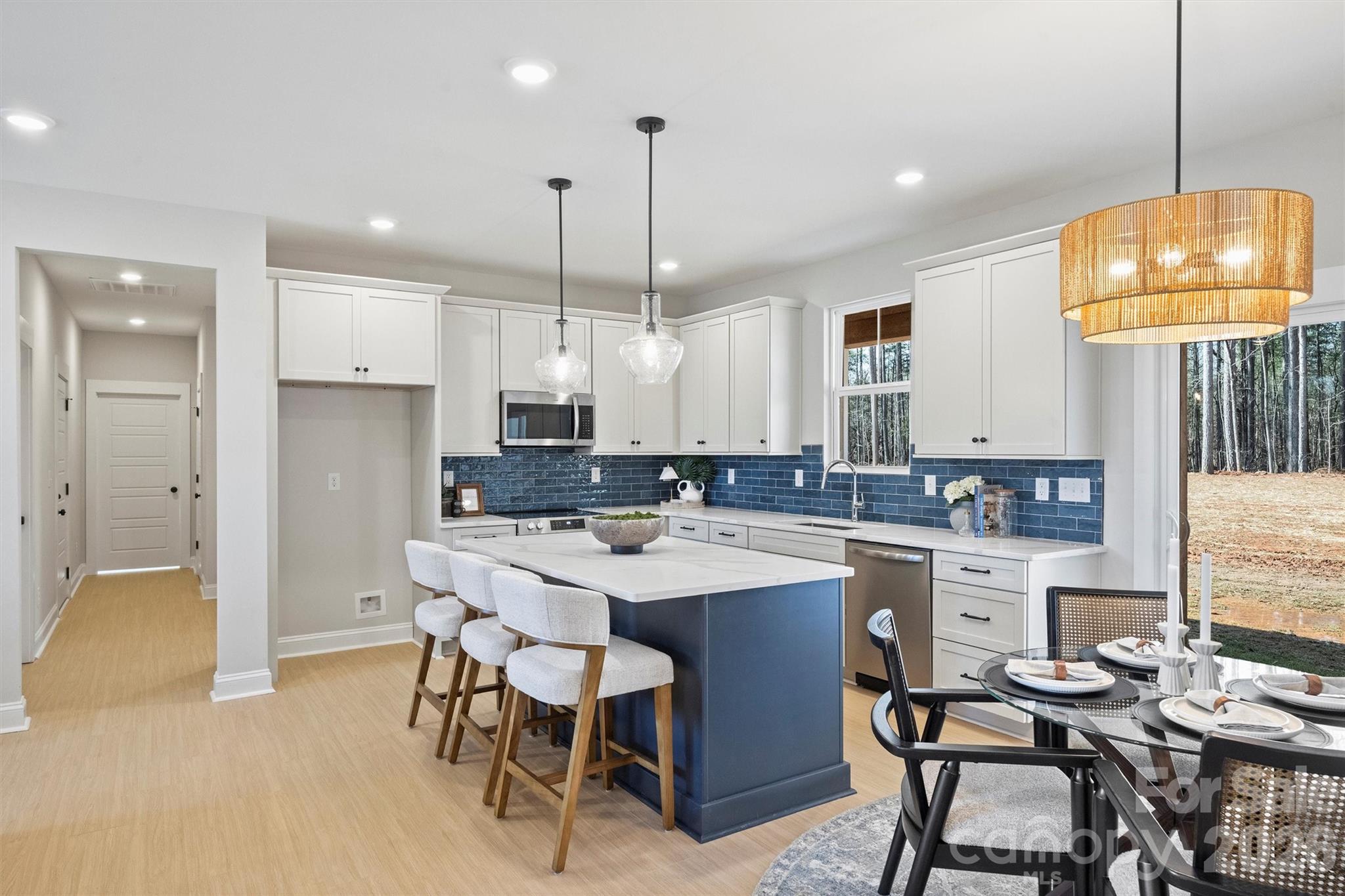 2295 Lee Lawing Road Lincolnton, NC 28092 - Photo 13 of 43 a kitchen with kitchen island a dining table chairs sink and white cabinets