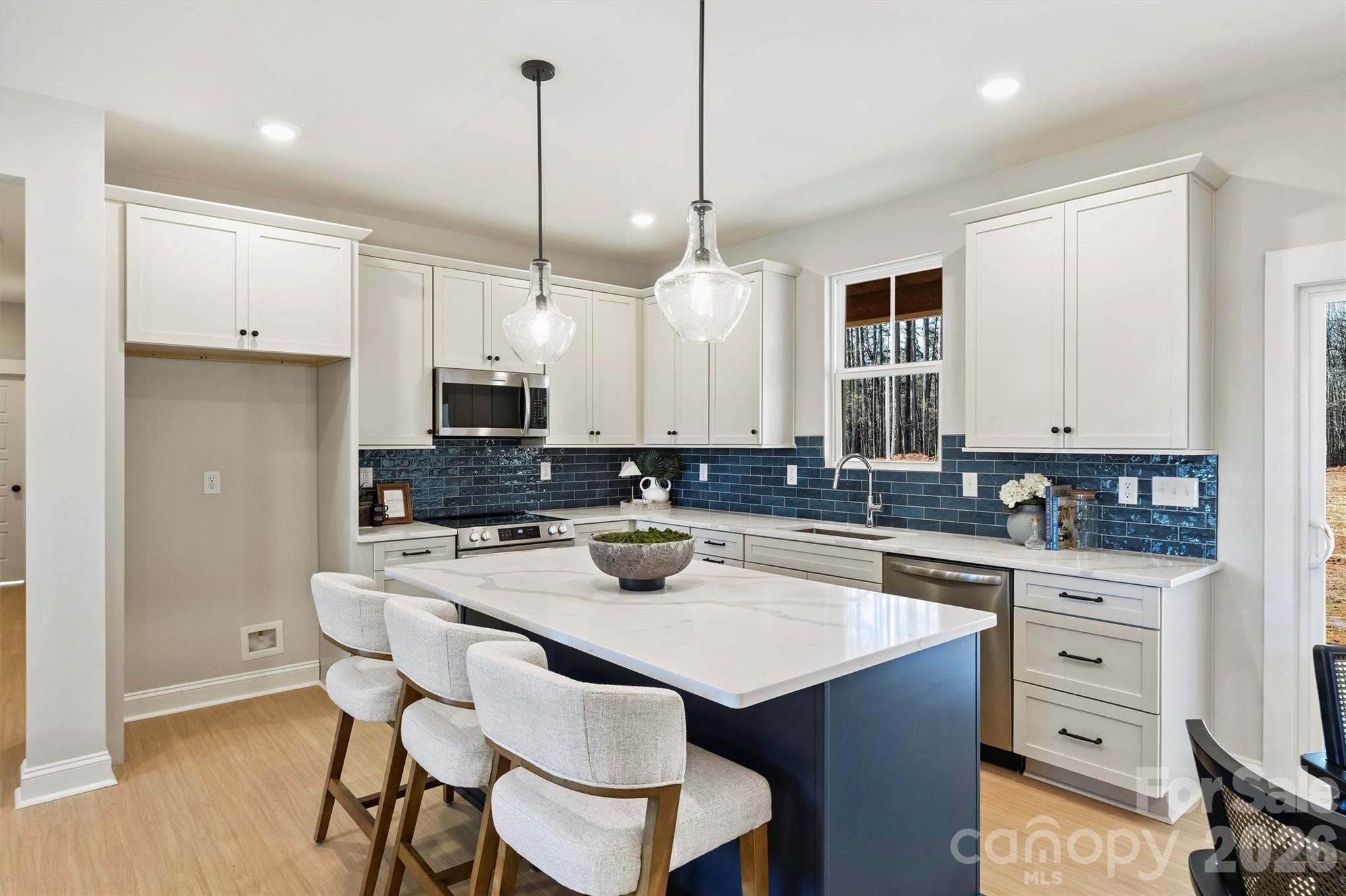2295 Lee Lawing Road Lincolnton, NC 28092 - Photo 14 of 43 a kitchen with a sink stove and white cabinets with wooden floor