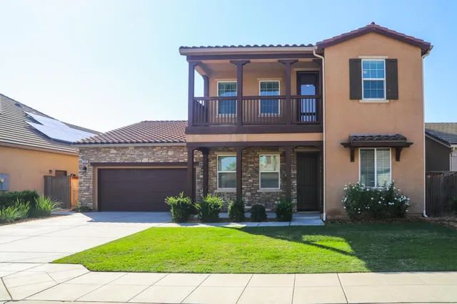 a front view of a house with a garden and plants