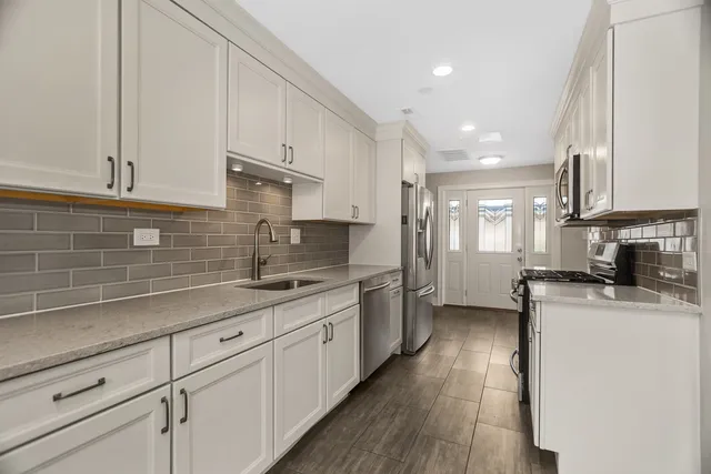 a kitchen with granite countertop a sink a counter top space and cabinets
