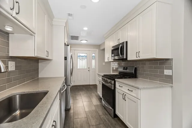 a kitchen with stainless steel appliances granite countertop a sink stove and refrigerator