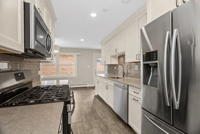 a kitchen with stainless steel appliances granite countertop a stove a refrigerator and a sink