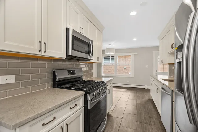 a kitchen with stainless steel appliances a stove a sink and a refrigerator