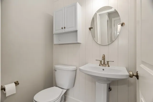 a bathroom with a toilet sink and mirror