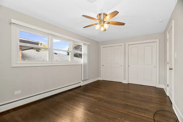 a view of a livingroom with wooden floor and a ceiling fan