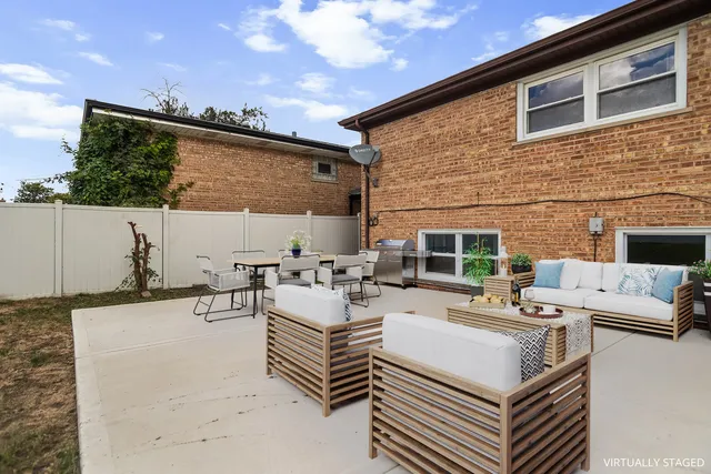 a view of a patio with couches table and chairs with potted plants
