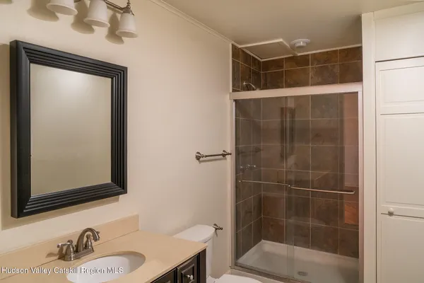 a bathroom with a shower a sink and a mirror