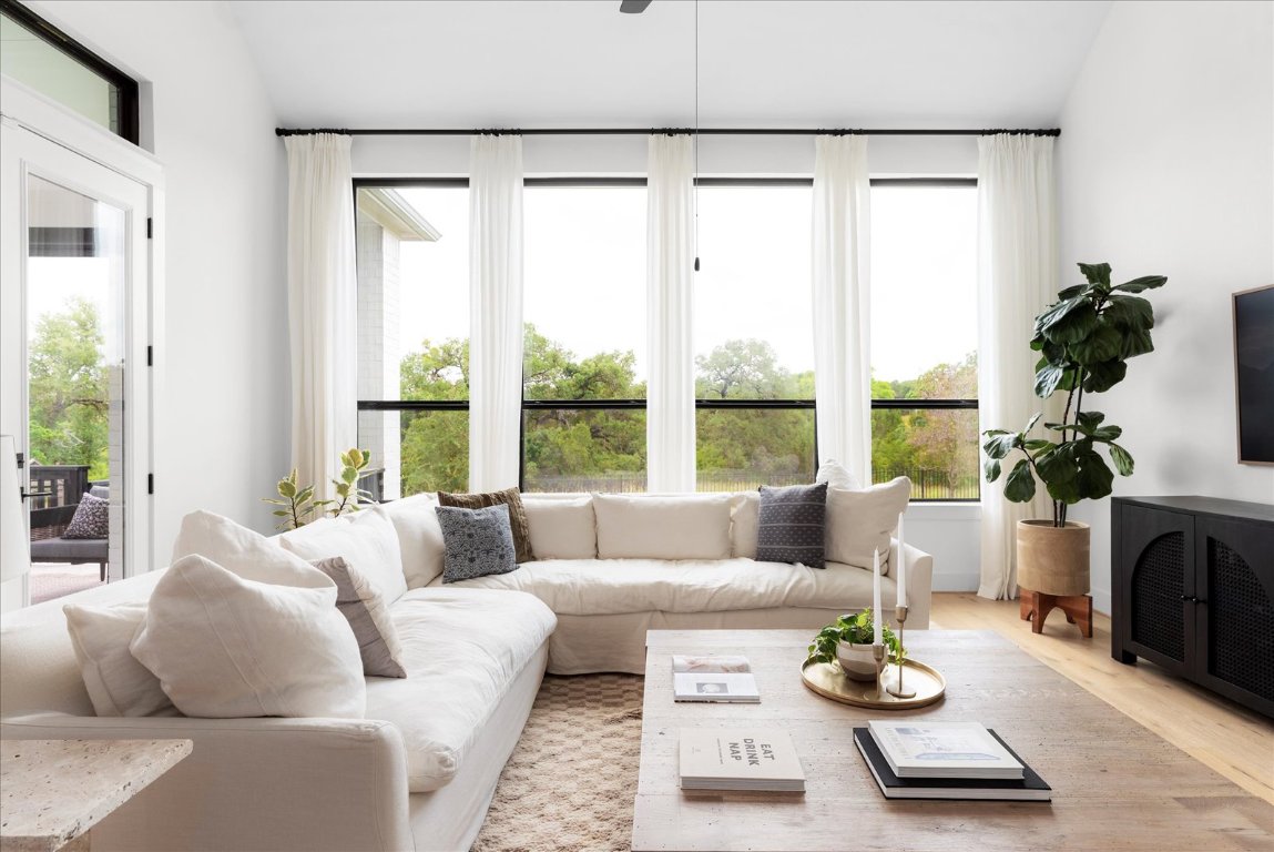 482 Running Bird Road Austin, TX 78737 - Photo 18 of 38 Bold black windows frame expansive views, bringing in abundant light and elevating the room’s spacious feel.