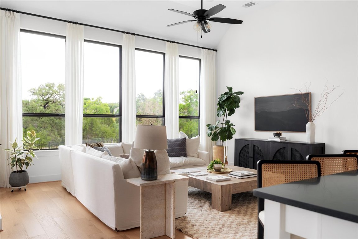 482 Running Bird Road Austin, TX 78737 - Photo 19 of 38 Bold black windows frame expansive views, bringing in abundant light and elevating the room’s spacious feel.