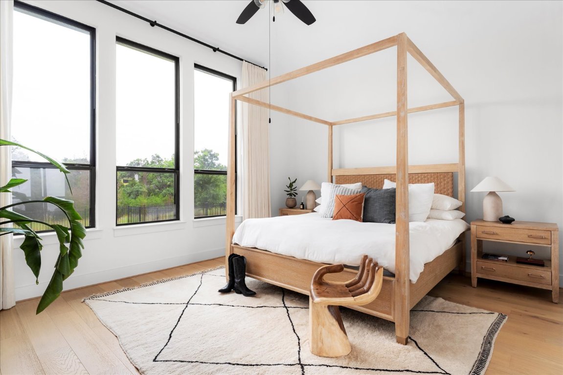 482 Running Bird Road Austin, TX 78737 - Photo 20 of 38 Wake up to nature’s beauty in this peaceful primary bedroom, complete with expansive windows and custom treatments for the perfect balance of light and privacy.