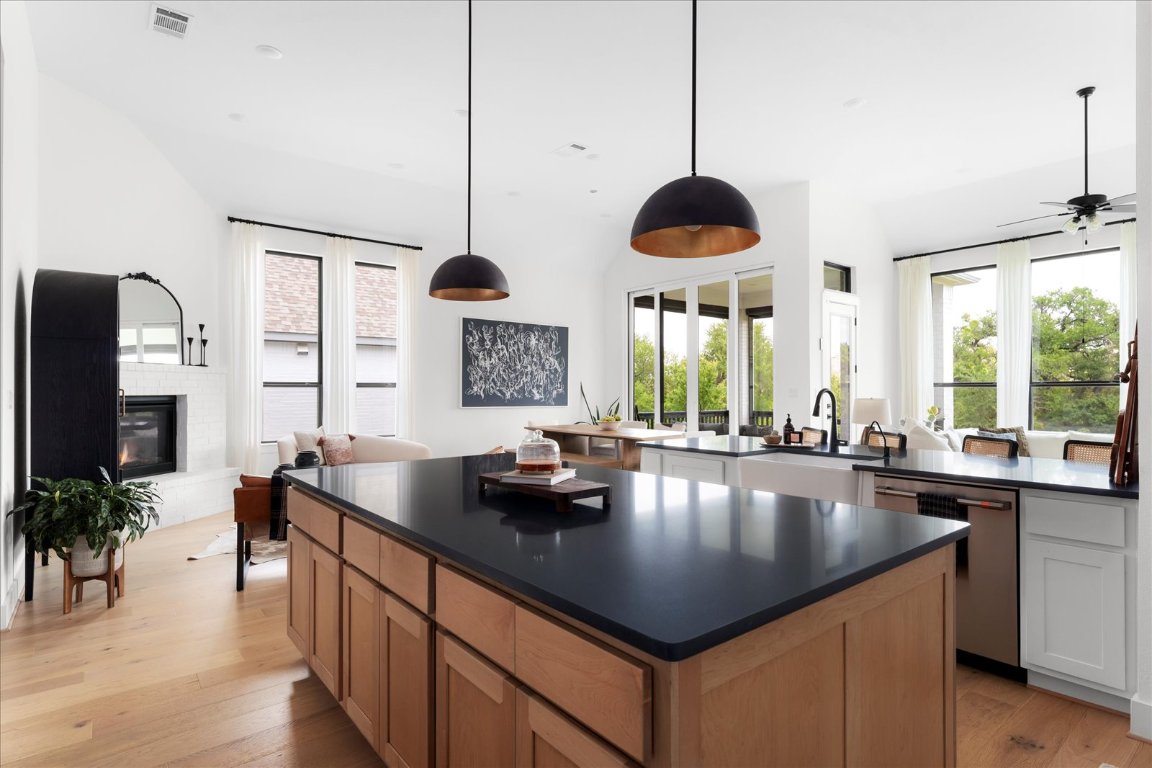482 Running Bird Road Austin, TX 78737 - Photo 2 of 38 A chef’s dream kitchen with double islands, ceiling-height custom cabinetry, under-cabinet lighting, a farmhouse sink, double ovens, and designer pendant lights that complete the elevated look.