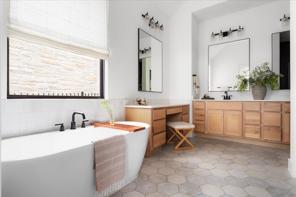 482 Running Bird Road Austin, TX 78737 - Photo 23 of 38 Bright and beautifully upgraded a freestanding tub framed by a window with custom shade, double vanities, and a generous walk-in shower.