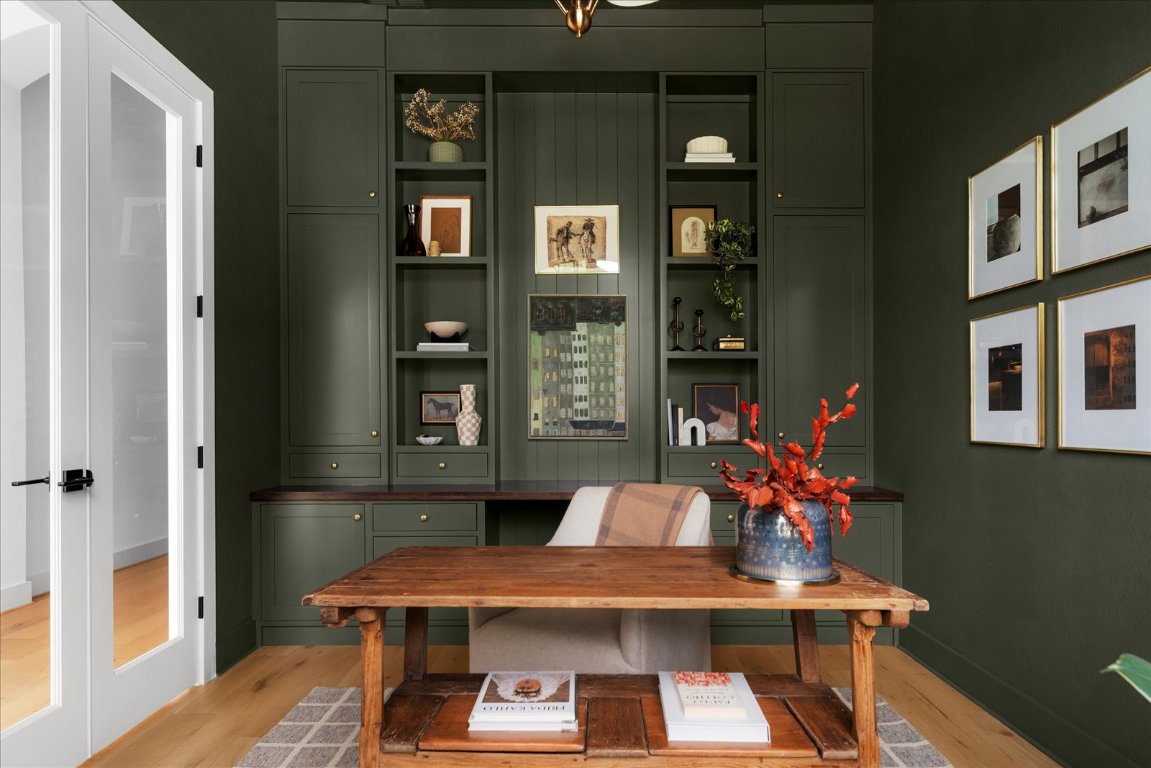 482 Running Bird Road Austin, TX 78737 - Photo 3 of 38 Rich in character and perfect for focus this dark olive office features tailored window treatments, custom shelving, and a chandelier.