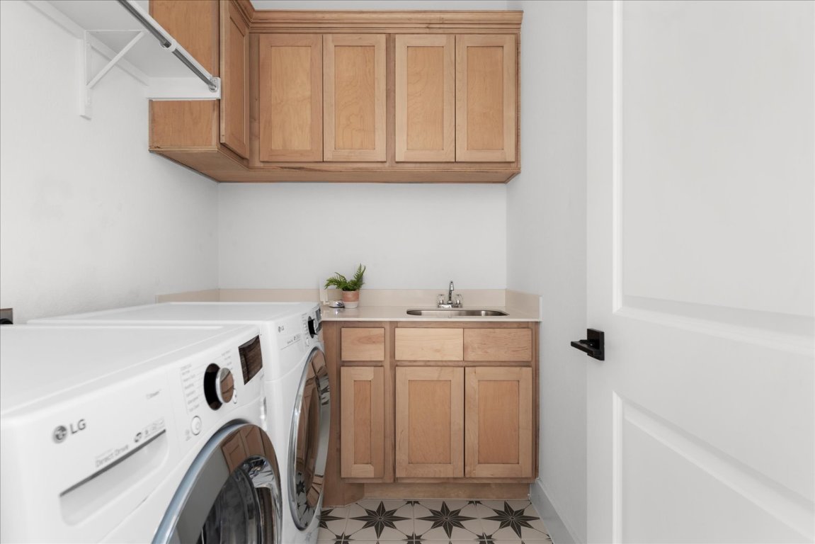 482 Running Bird Road Austin, TX 78737 - Photo 33 of 38 Laundry area featuring cabinet space, washer and dryer, and counter with sink.