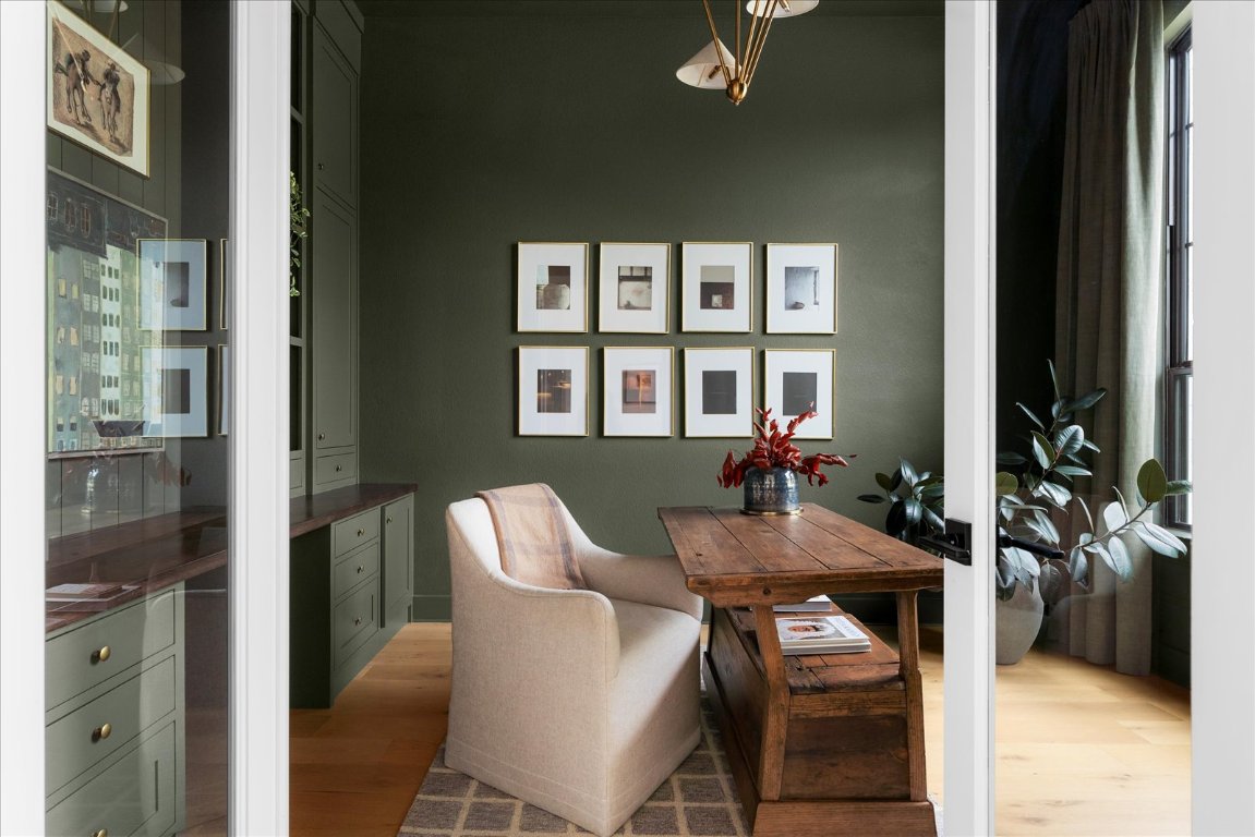 482 Running Bird Road Austin, TX 78737 - Photo 4 of 38 Rich in character and perfect for focus this dark olive office features tailored window treatments, custom shelving, and a chandelier.