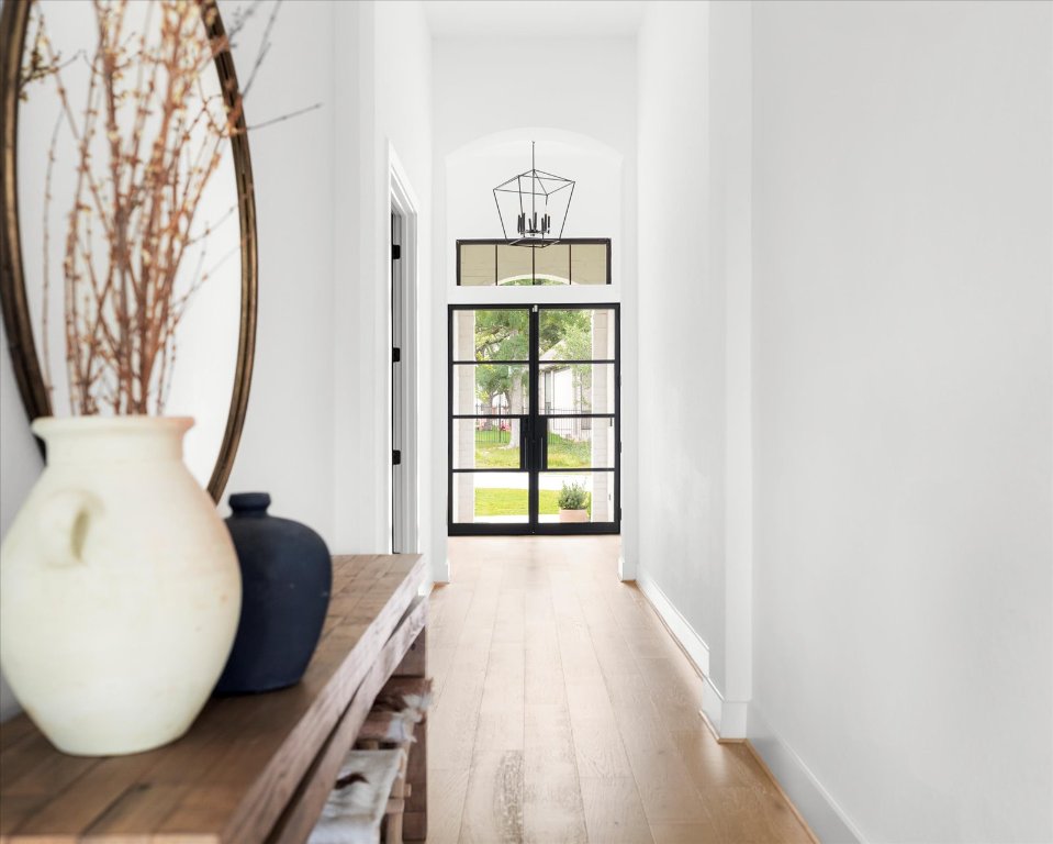 482 Running Bird Road Austin, TX 78737 - Photo 6 of 38 Natural light pours into a stunning entryway with high ceilings, oak wood floors, and designer trim details.