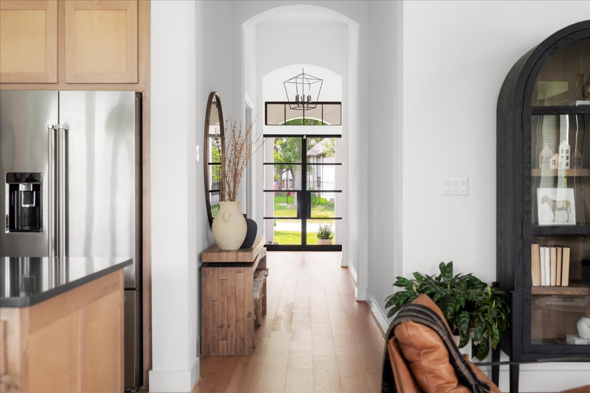 482 Running Bird Road Austin, TX 78737 - Photo 7 of 38 Corridor featuring arched walkways, light wood-style floors, and baseboards.