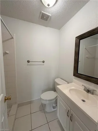 a bathroom with a granite countertop toilet a sink and mirror