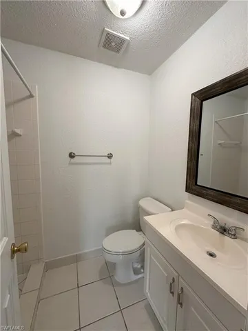 a bathroom with a granite countertop toilet a sink and mirror