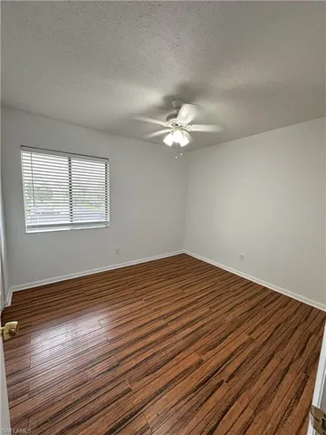 a view of a room with wooden floor and white walls