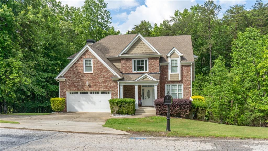 a front view of a house with a yard and trees