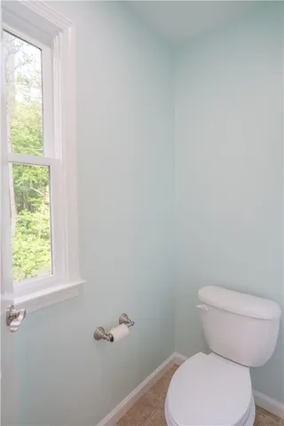 a white toilet sitting next to a window