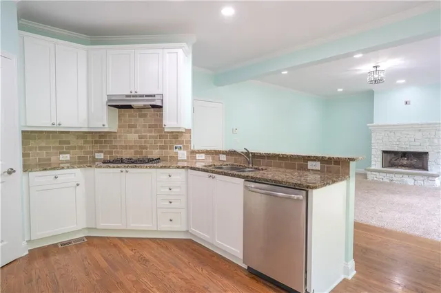 a kitchen with stainless steel appliances granite countertop a stove and white cabinets