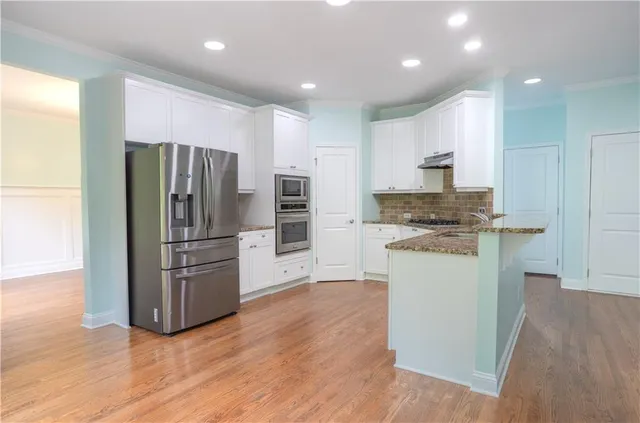 a kitchen with stainless steel appliances a refrigerator stove microwave and cabinets