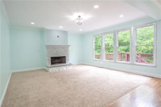 a view of an empty room with a fireplace and a large window