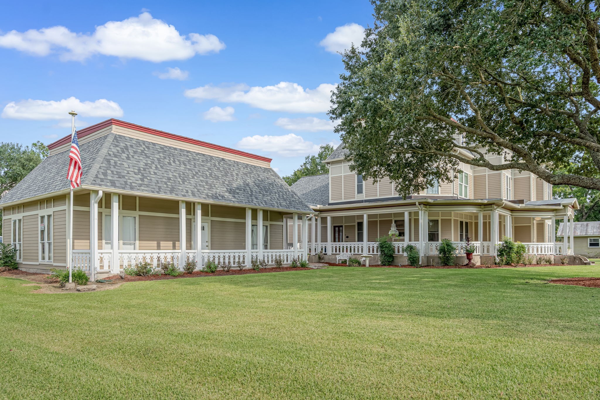 4028 Crosby Cedar Bayou Road Baytown, TX 77521 - Photo 6 of 35 This refined side elevation showcases the home’s architectural harmony: a sweeping wraparound veranda links the main residence to an expansive single-story wing and wraps seamlessly to the three-car garage, creating a sheltered, elegant approach for everyday arrivals and entertaining. Framed by a majestic oak and manicured grounds, the setting is timeless.