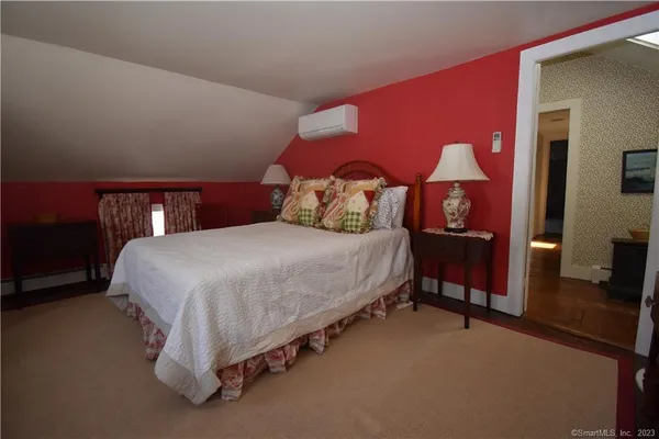 a bedroom with a bed and a lamp on dresser