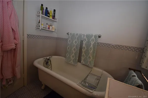 a bathroom with a bathtub and shelf