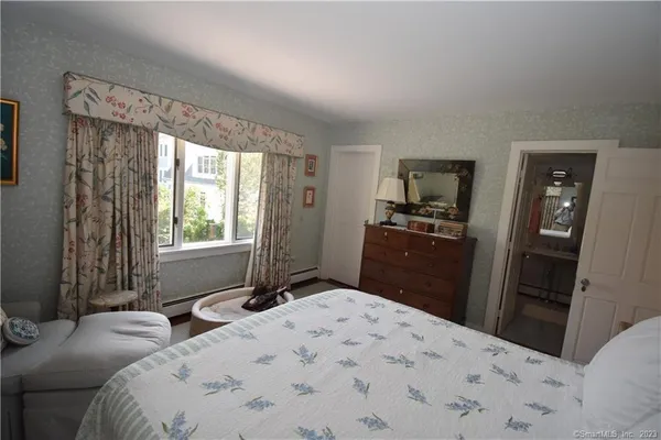 a bedroom with a bed and a large mirror